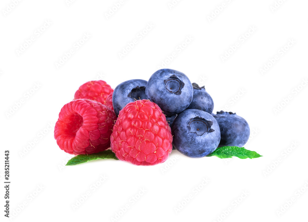 Raspberries with blueberries and mint leaves isolated on white background
