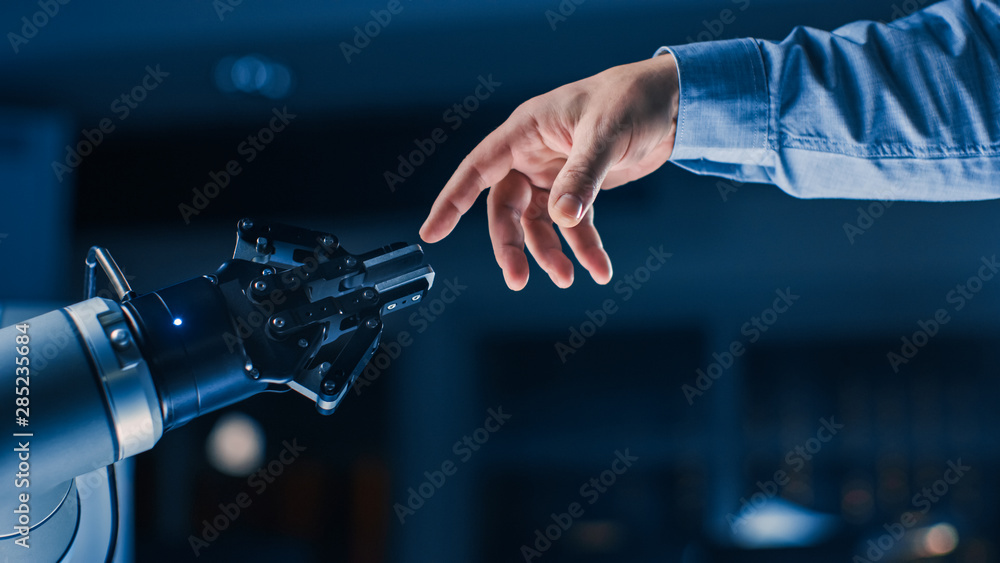 未来主义机器人手臂在人类与人工智能统一手势中触摸人手。Co