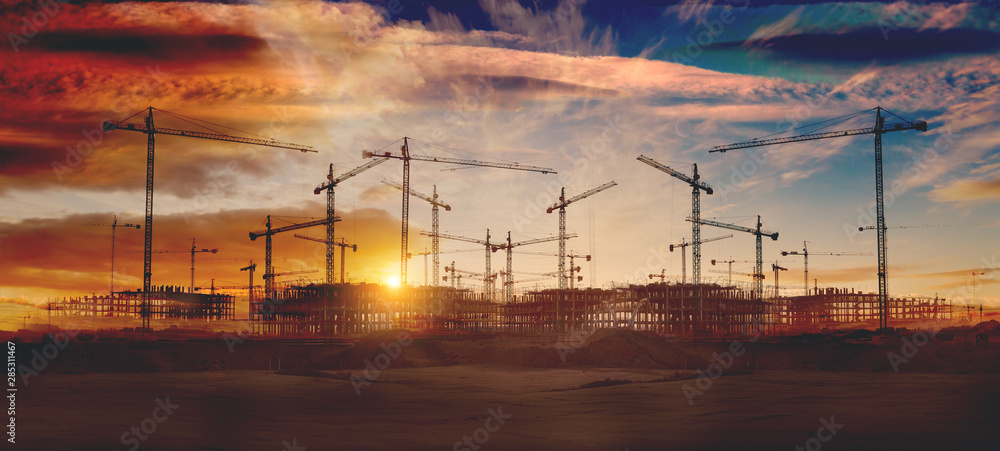 Gruas de construcción y puesta de sol.Concepto de industria y mercado inmobiliario..Cimientos de blo
