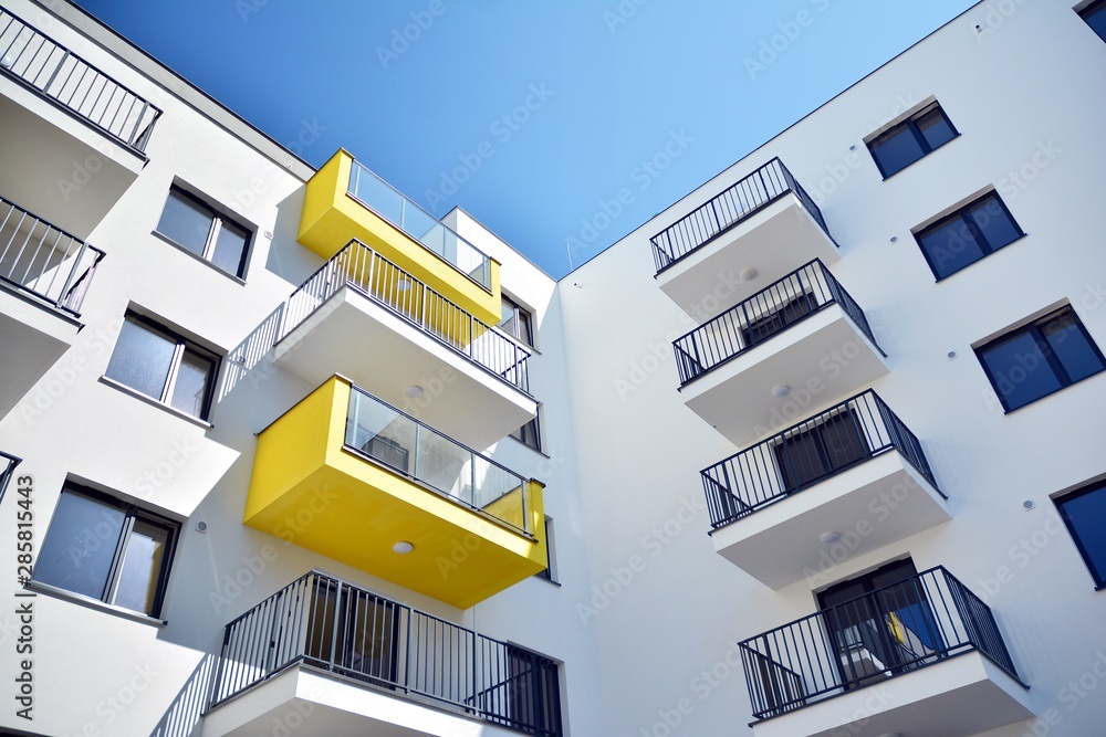 阳光明媚的蓝天下的现代公寓楼。现代公寓楼的立面