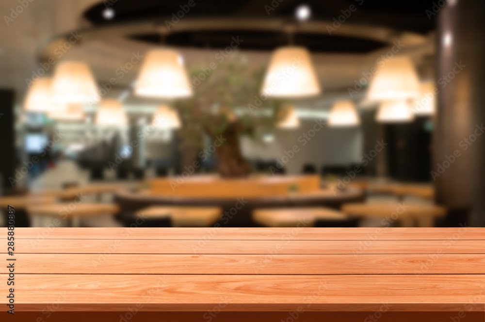 Wood table in blurry background of modern restaurant room or coffee shop with empty copy space on th