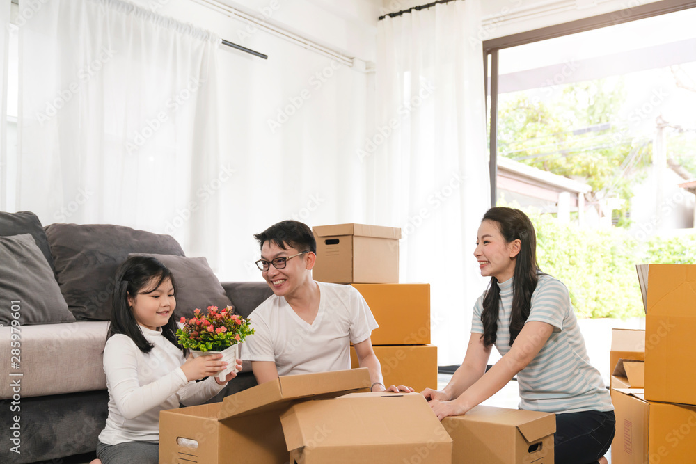 亚洲幸福家庭微笑手提箱打开新家里的东西搬家理念