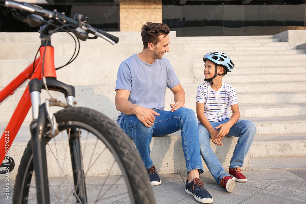 Father and his little son with bicycle outdoors