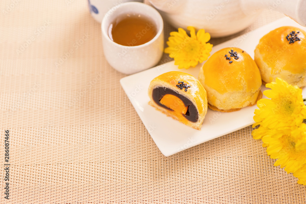 中秋节美味的烤蛋黄糕点月饼，背景是明亮的木桌。Chi