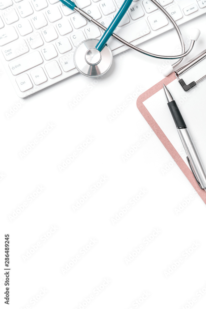 医生诊断概念-电脑键盘上的听诊器，带有病历箱和笔