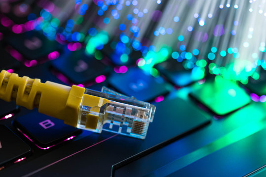 黄色网络开关rgb游戏笔记本电脑键盘，发光的光纤在背景。
