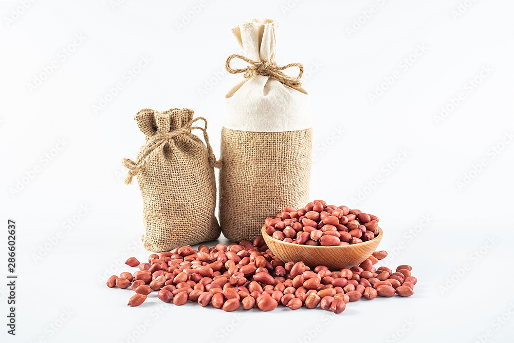 Sacks filled with grain and a bowl of peanuts on a white background