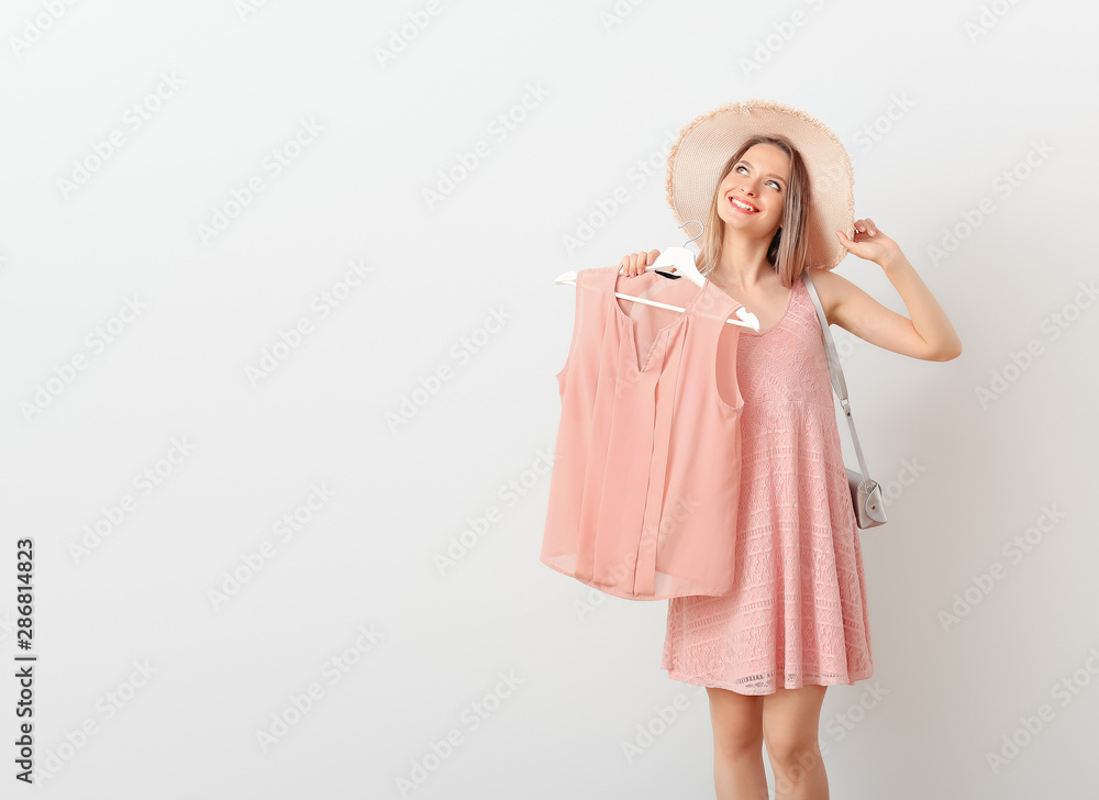 Young woman with stylish clothes and accessories on white background