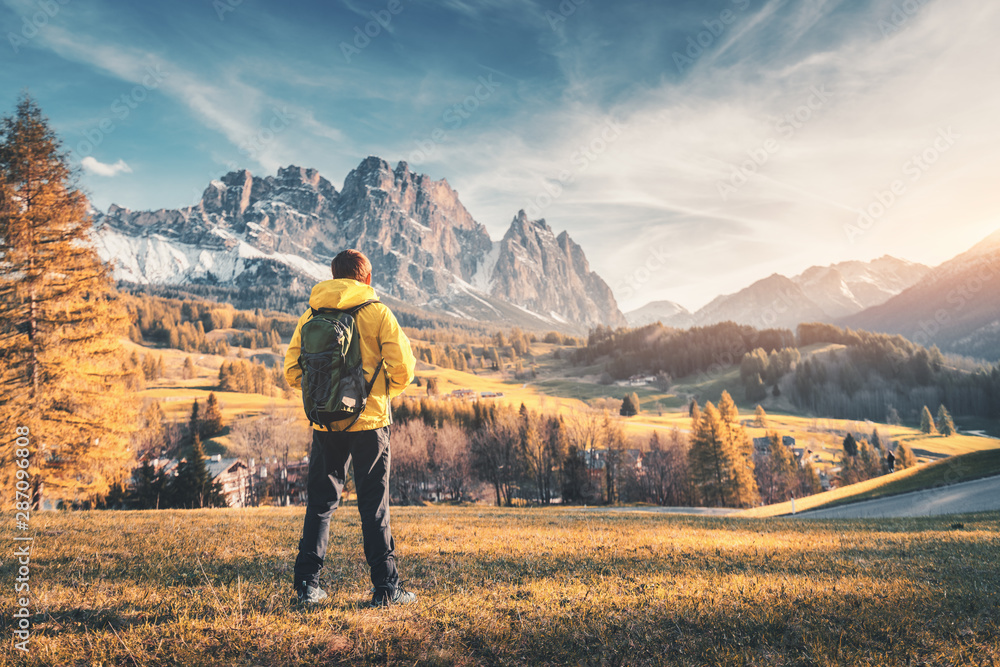 秋天日落时，背着背包的年轻人站在靠山的小山上。风景wi