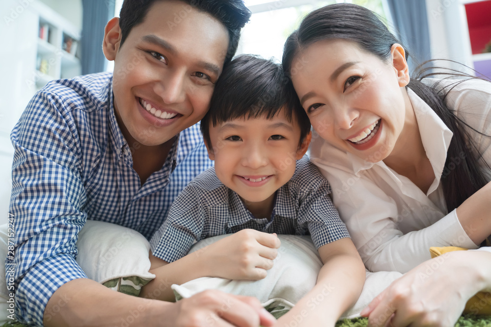 幸福的亚洲家庭在客厅的沙发上共度时光。家庭和家的概念