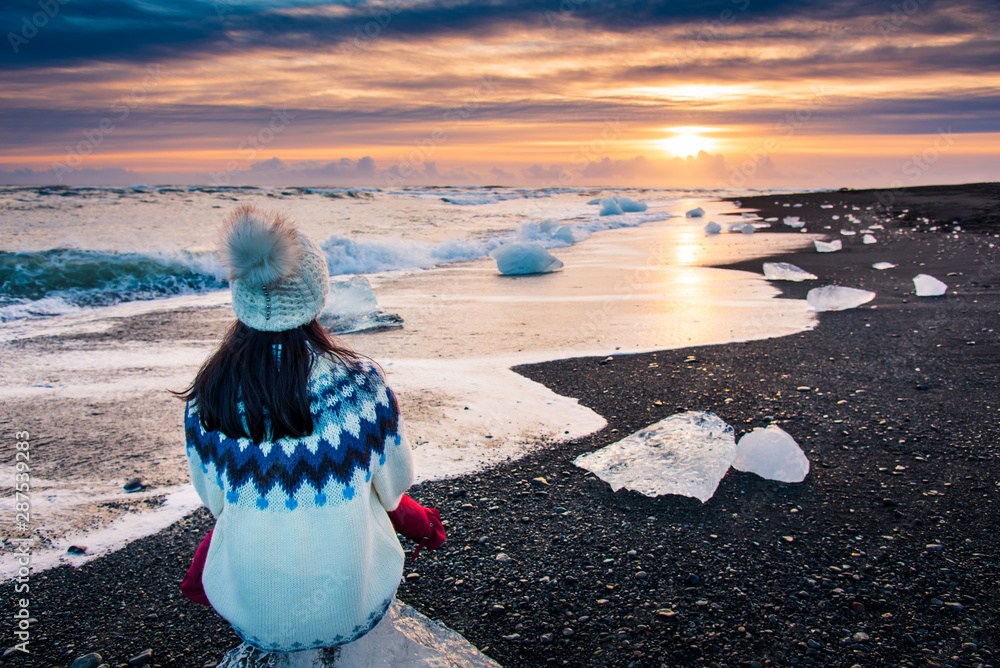 在冰岛欣赏钻石海滩日落的女人