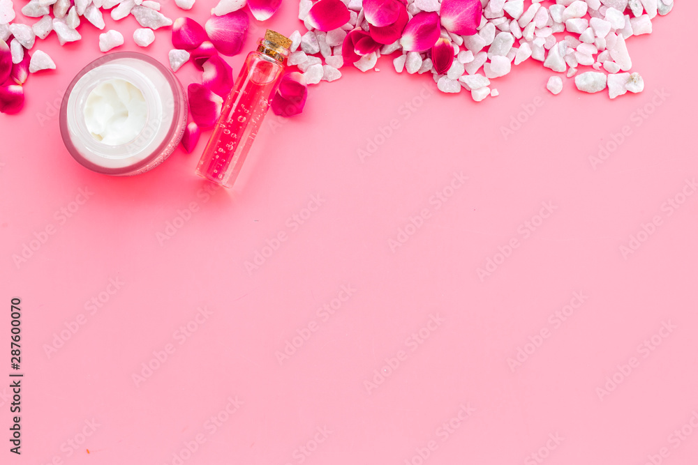 粉色背景的小石头框架和玫瑰化妆品模型俯视图