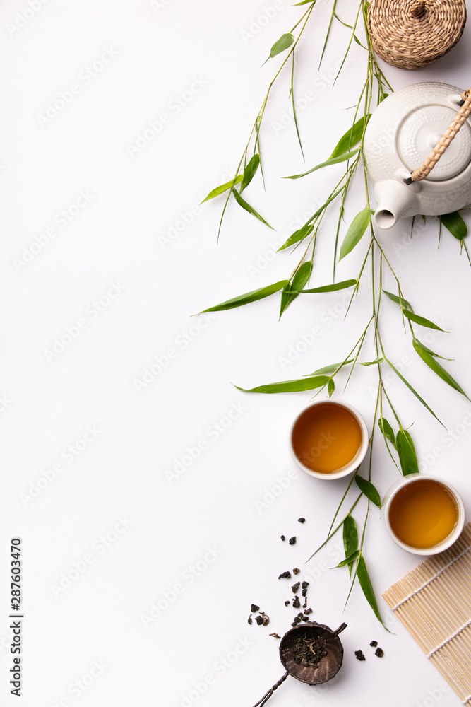 以绿茶、杯子和竹枝茶壶为背景的亚洲美食