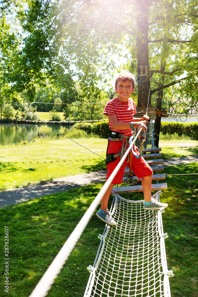 Boy plays in the children rope net playground