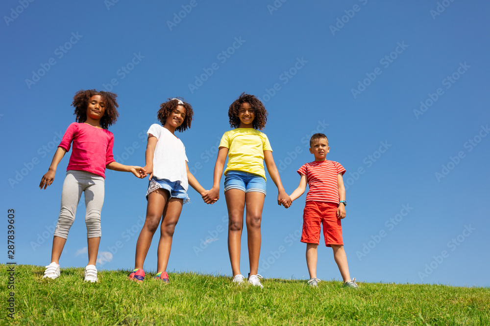 一群孩子手牵着手站在干净的天空上