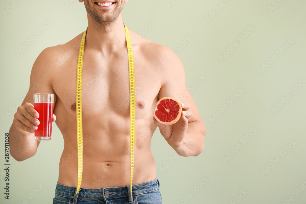 带着卷尺、葡萄柚和果汁的英俊肌肉男。减肥骗局