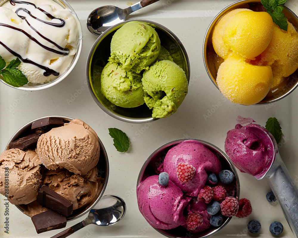 Assorted flavors and colors of gourmet Italian ice cream served on steel table. Mango, chocolate, gr