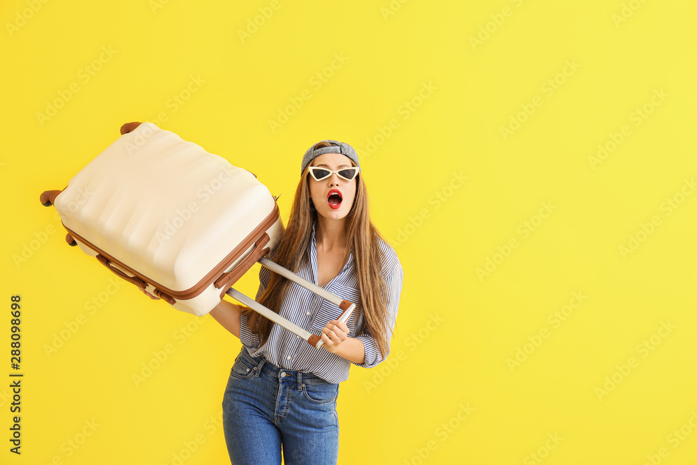 震惊的年轻女子带着彩色背景的行李箱