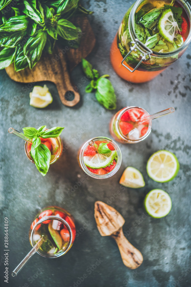 Homemade fresh strawberry and basil lemonade or ice tea in glass tumblers with eco-friendly plastic-