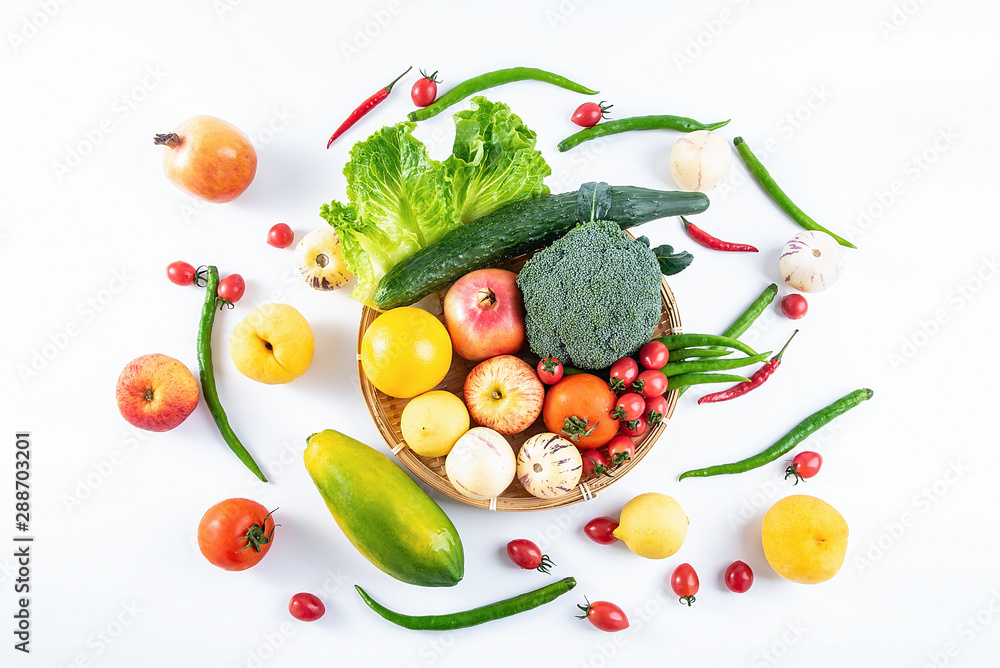 一个竹盘子，白色背景上装满了新鲜的时令蔬菜和水果