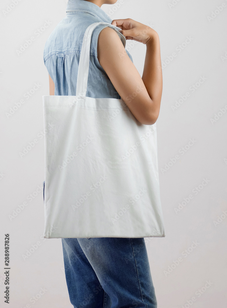 年轻女子拿着白色背景的生态棉袋