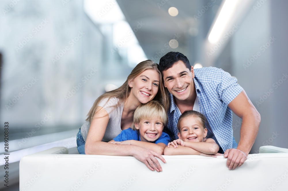 美丽的微笑家庭在沙发上的房间里