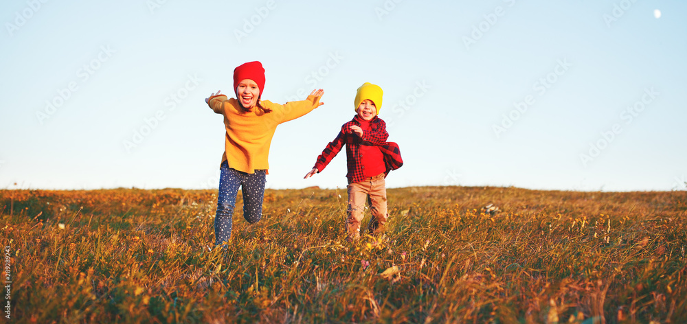 快乐的孩子们，男孩和女孩在秋天的自然漫步中奔跑和欢笑