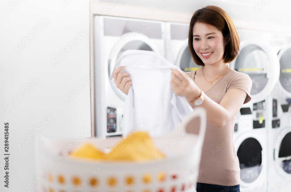 亚洲女性看着从洗衣店洗下来的衬衫
