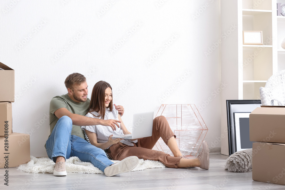 Young couple with laptop planning design of their new house