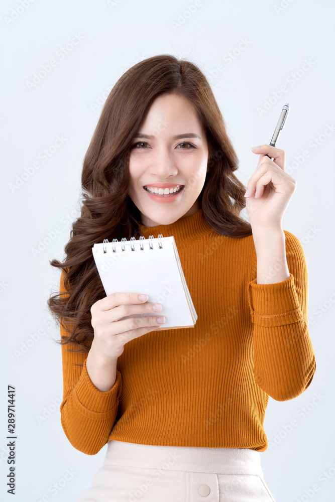 美丽优雅的亚洲女性棕色毛衣连衣裙手拿纸纸条和铅笔思考创意