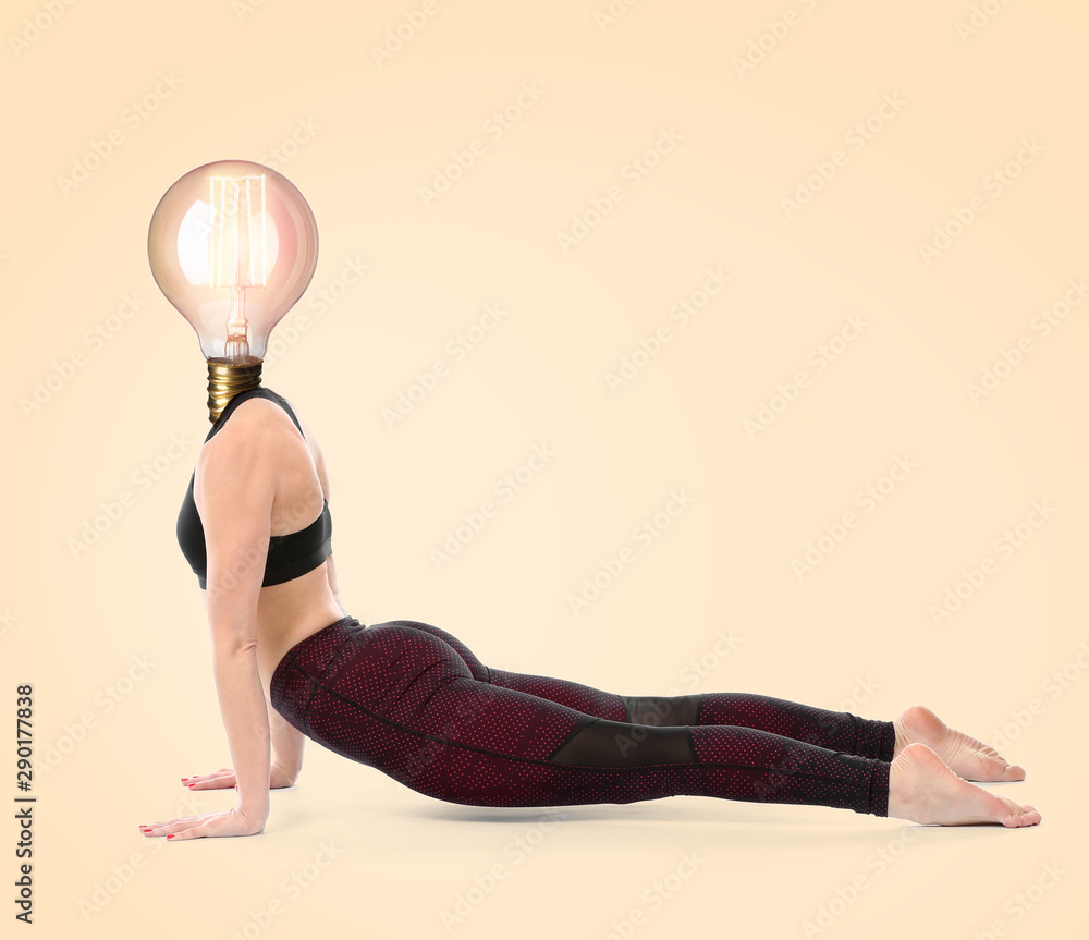 美丽的女人用灯泡代替她的头在彩色背景上练习瑜伽