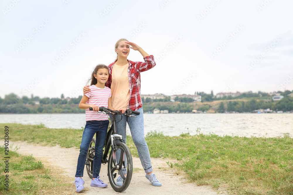 妇女和她的小女儿在户外骑自行车