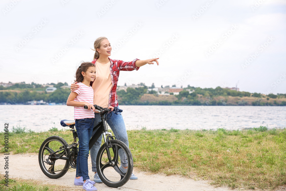 妇女和她的小女儿在户外骑自行车