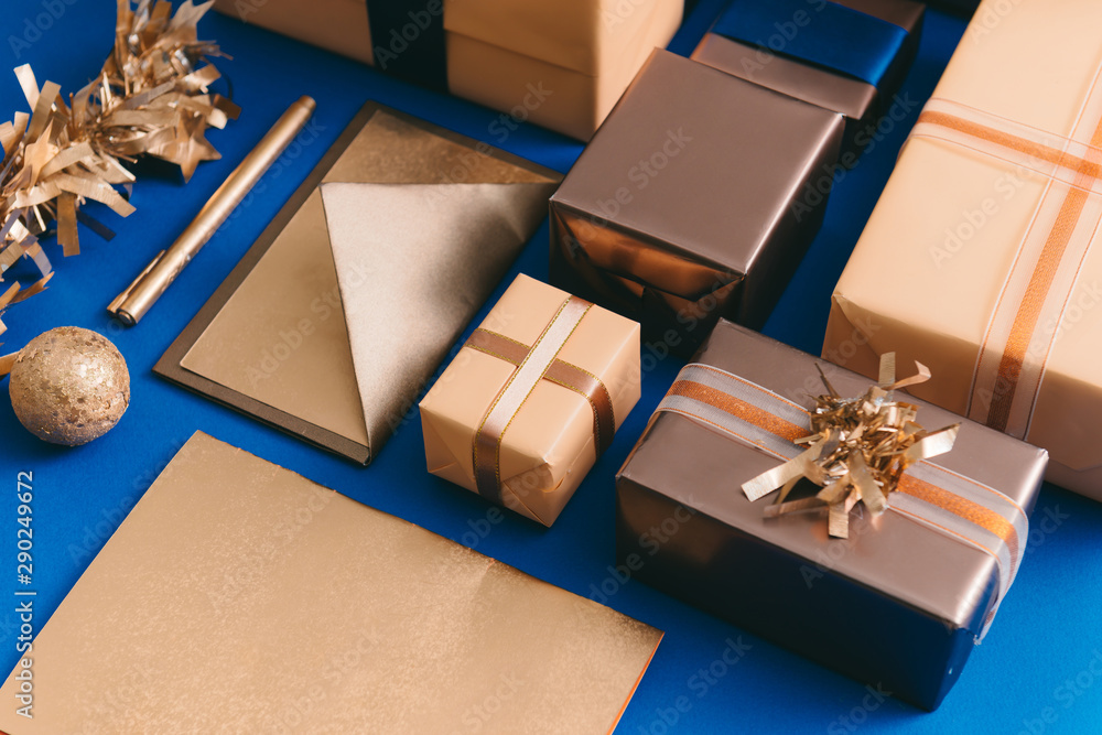 金色盒子、信封、蓝色背景花环的Chirsmas概念。
