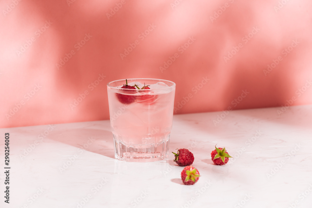 夏日果汁配新鲜树莓，装在玻璃杯中，背景为浅色