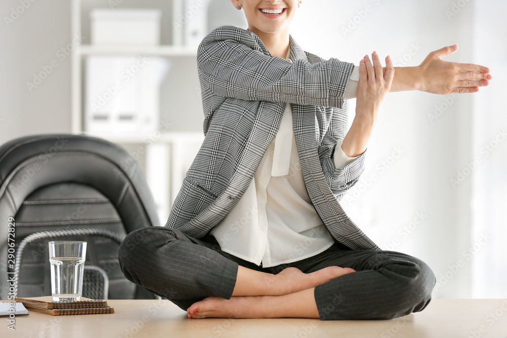 年轻女商人在办公室练习瑜伽