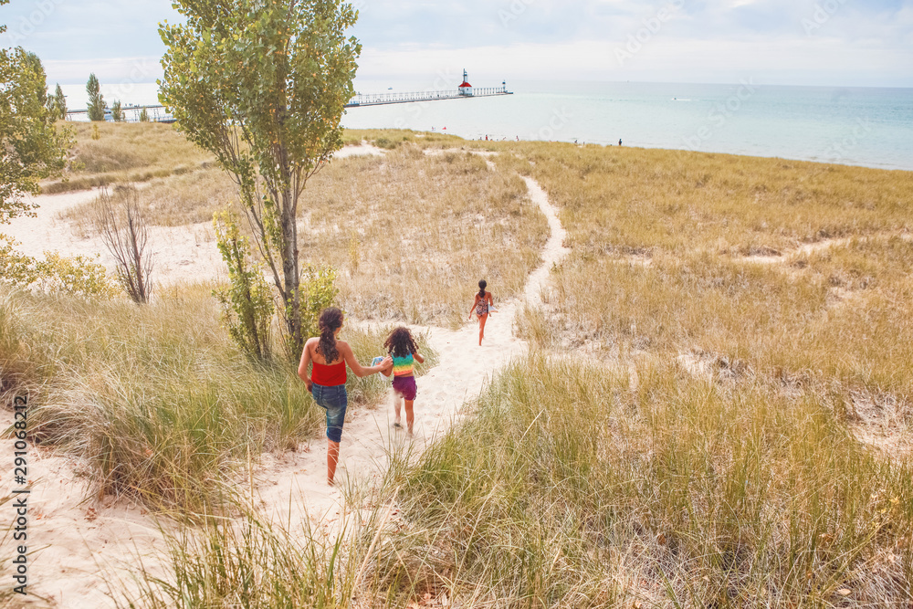 孩子们沿着沙丘小路跑向海滩