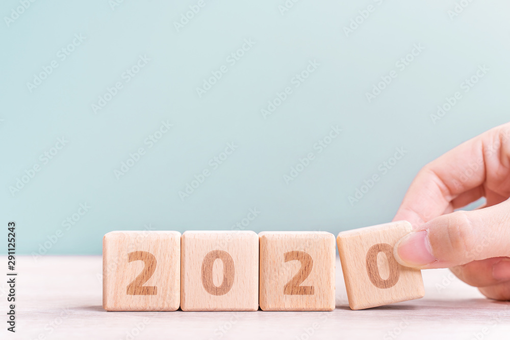 摘要2020和2019新年倒计时设计理念-妇女在木制t上拿着木块立方体