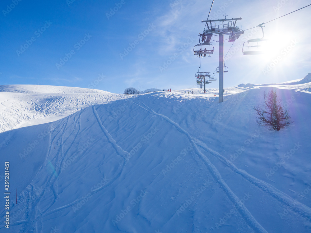 France, february 2019: Panoramic view of a snow covered alpine mountain range with chairlift ski lif