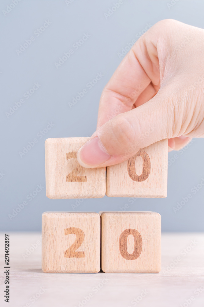 摘要2020和2019新年倒计时设计理念-妇女在木制t上拿着木块立方体