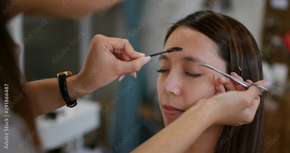 化妆师在工作室为女模特修眉