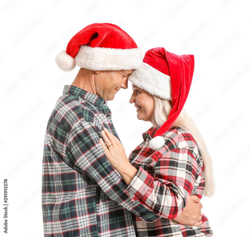 白色背景下戴着圣诞老人帽子的幸福成熟夫妇的肖像