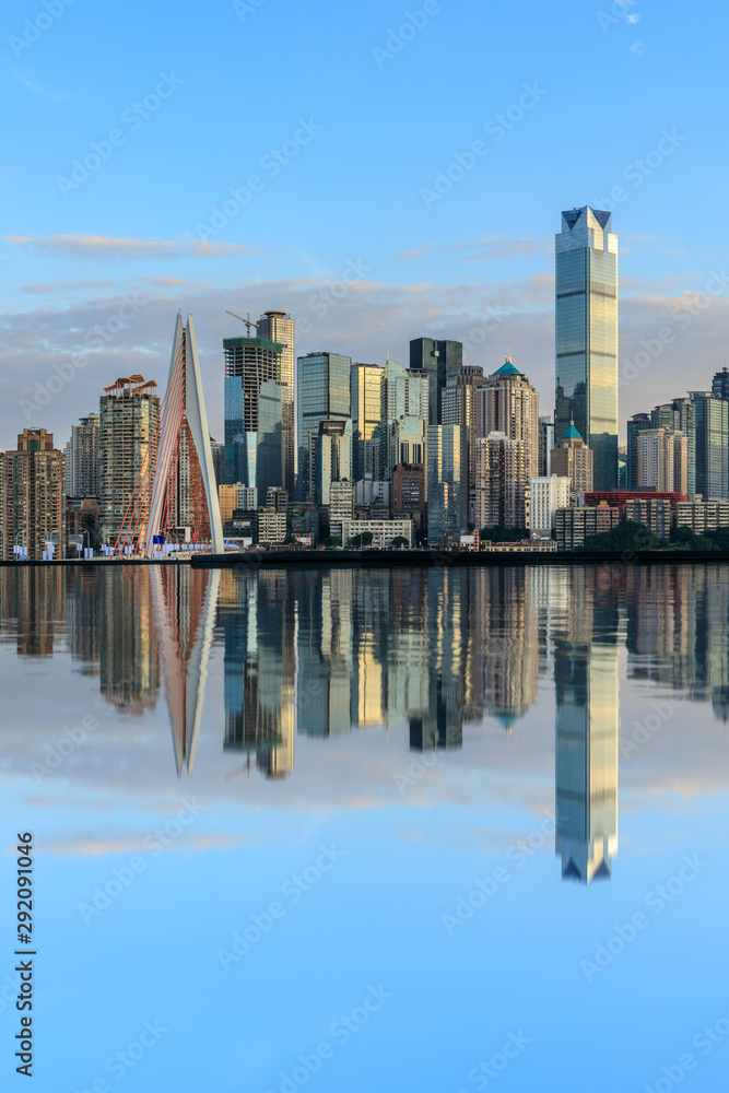 重庆天际线和现代城市摩天大楼，日落时水的倒影，中国。