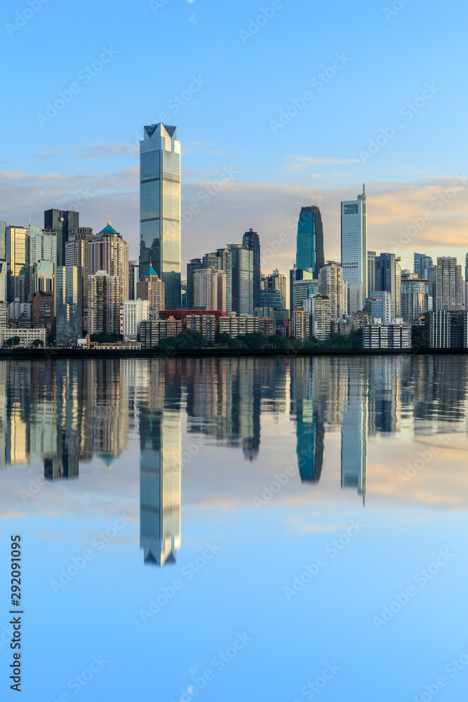 重庆天际线和现代城市摩天大楼，日落时水的倒影，中国。