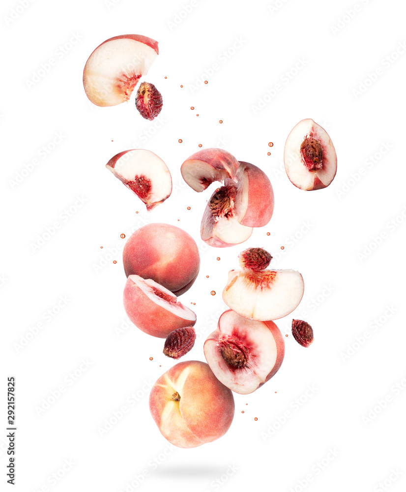 空气中的整颗和切片的新鲜桃子，在白色背景上隔离
