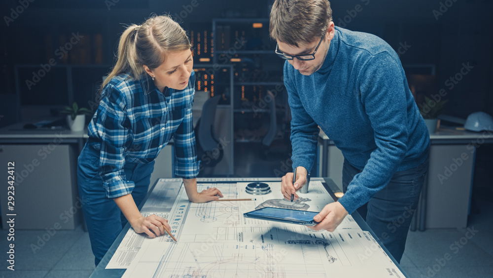 黑暗中的工业设计工程设施男工程师和女工程师在蓝色上交谈和工作