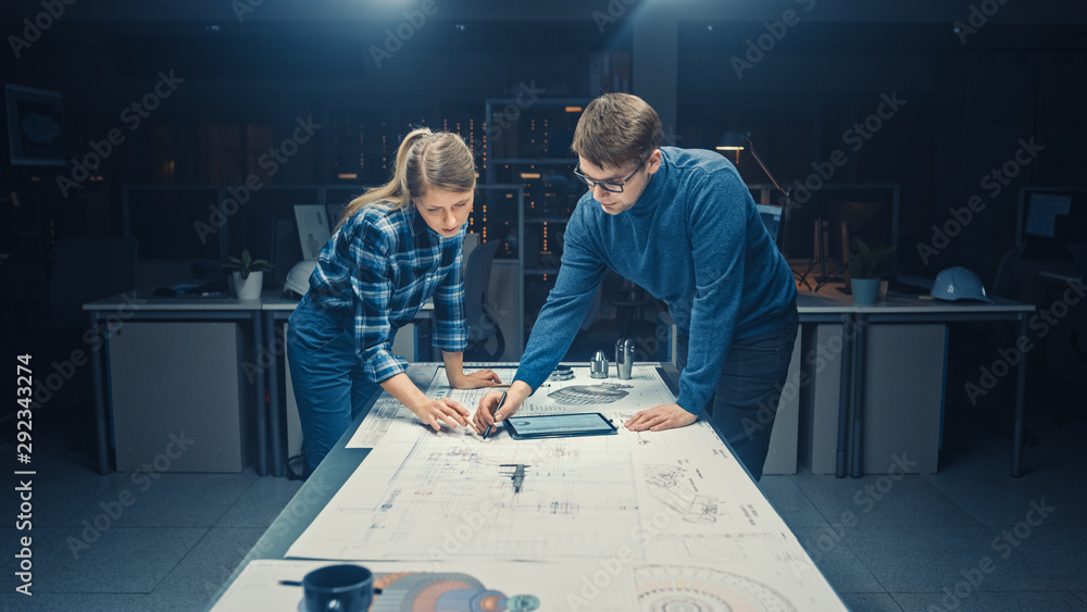 黑暗中的工业设计工程设施男工程师和女工程师在蓝色上交谈和工作