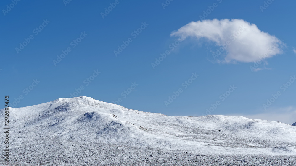 蓝天背景下的雪山上漂浮着白云，中国苏的美丽风景