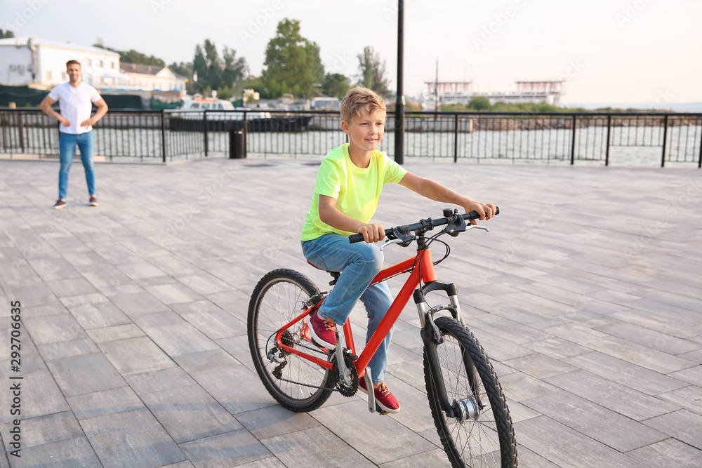 父亲为儿子在户外学会骑自行车感到骄傲