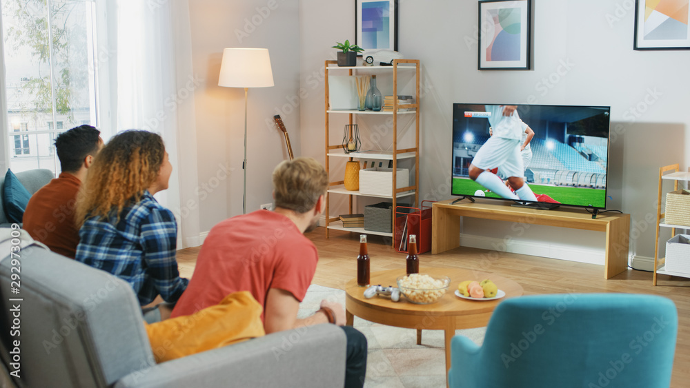 三名体育迷坐在客厅的沙发上观看重要的足球比赛，忧心忡忡